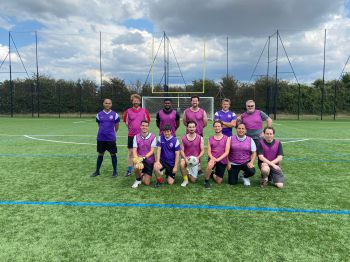 staff football team on the football pitch having a group photo together