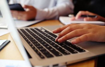 Close up of someone typing on a laptop