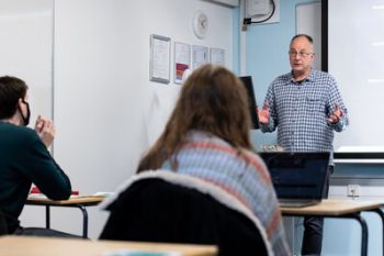 A lecturer talks to students