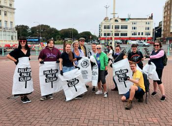 Educational Enhancement department members gather at Brighton's Palace Pier for charity beach clean