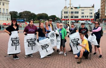 Educational Enhancement department members gather at Brighton's Palace Pier for charity beach clean