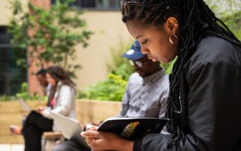 Student reading in the Student Centre Courtyard