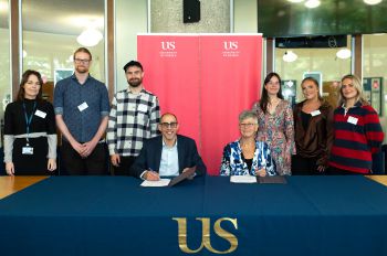 Students and staff in the Meeting House, with University of Sussex banners