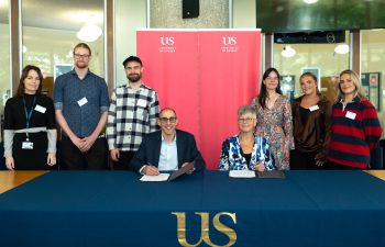 Students and staff in the Meeting House, with University of Sussex banners