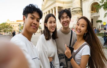 A group of students taking a selfie in front of an ancient landmark.