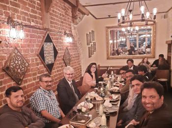 Group for faculty and visitors seated around a restaurant table