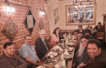 Group for faculty and visitors seated around a restaurant table