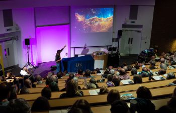 Prof Stephen Wilkins pointing at an image taken by the James Webb Space Telescope on a big digital screen