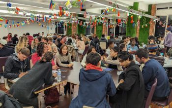 Students sitting around tables chatting at a Language Café event