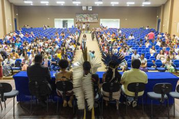 Five panelists sit at the podium while participants of the forum gather in a lecture hall at the State University of Santa Cruz