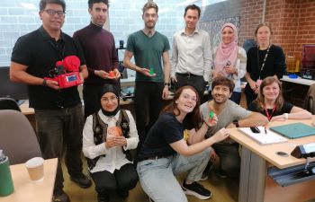 Group of students seated and standing posing with their 3D models