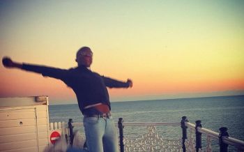 Benjy jumping into the air at Brighton Beach with the sun setting in the background