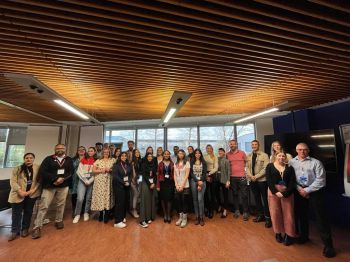 A group of Sussex students standing and grouped in front of a window at the Roche office in Burgess Hill