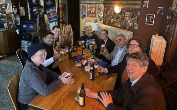 A group of alumni sitting around a table with drinks