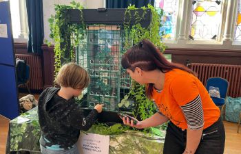 Professor Gilly Forrester timing a young visitor taking part in the Great Ape Challenge