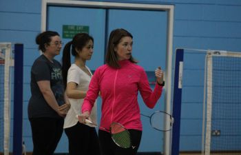 A badminton coach and two female players
