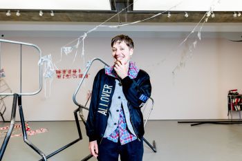Jesse Darling, winner of the Turner Prize 2023 smiling in front of his exhibition