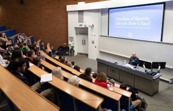 David Ruebain delivering a lecture in front of a large audience