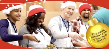 Four people dressed up with Christmas hats and giving away
