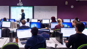 A mixed class of PHD students with laptops and lecturer