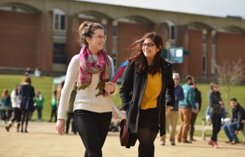 Students walking across library square on campus