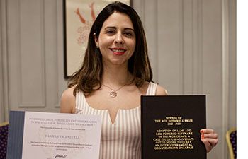 Daniela Valenzuela, winner of Rothwell prize, holding their dissertation