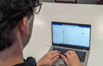 Man typing on a laptop displaying the Teams Calling screen