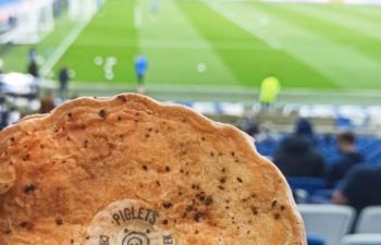 someone holding up a piglet's pantry pie at the Amex stadium