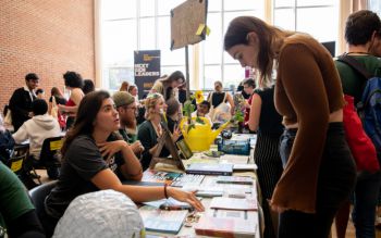 A student speaking to someone at a Freshers' Fair stand