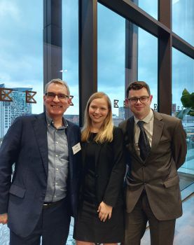 A photograph of Carolyn and Joe smiling alongside Dr Richard Glover