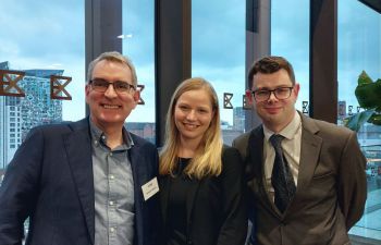 A photograph of Carolyn and Joe smiling alongside Dr Richard Glover