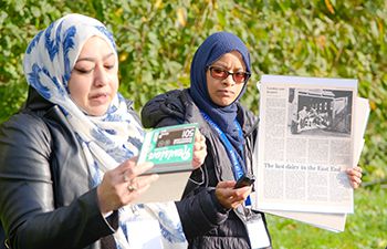 Community researchers holding a newspaper