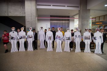 Young men standing with their life-size versions of themselves