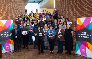 A group photo of the winners of the Education Awards holding their awards at the Attenborough Centre for the Creative Arts