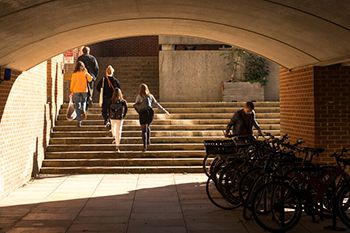 Five people going upstairs and one person by the bikes' parking