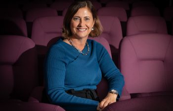 A photograph of Ali Ramsey sitting in a cinema