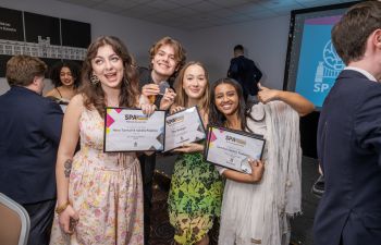 Photo of four students from MAH smiling as they hold up their awards