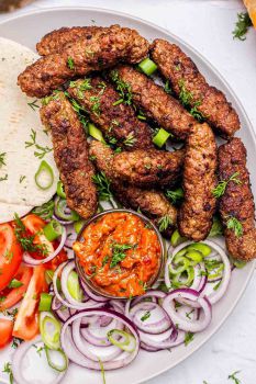 Balkan sausages served with salad and flatbread