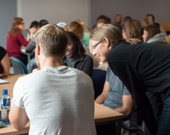 A photo of a lecturer explaining and supporting students