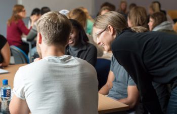 A photo of a lecturer explaining and supporting students