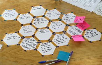 Picture of cardboard Hexagons on desk as part of an action plan activity