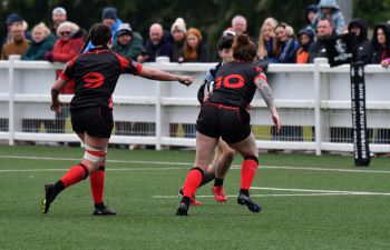 a member of the England deaf women's rugby team running in for a tackle