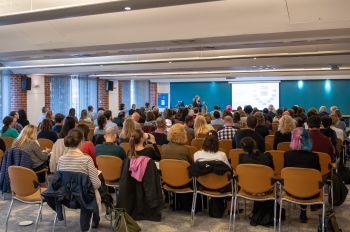 People sat on chairs in a room watching a lecture at the HRP conference