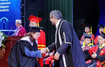 A ZJSU student receives their degree from Robin Banerjee