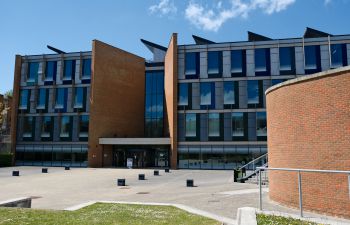 The front of Jubilee building on a sunny day with blue sky and grass in the foreground