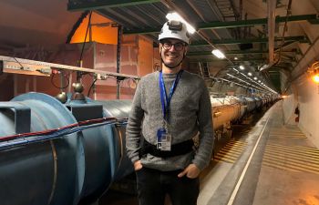 A man wearing a workman hat standing in a tunnel