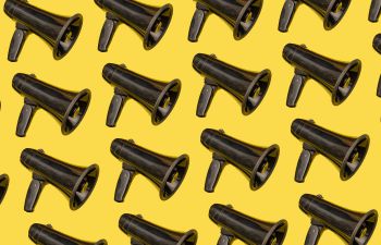 An image of a megaphone printed multiple times across a bright yellow background