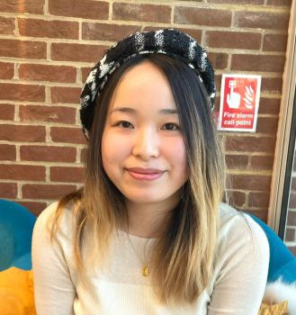 Cooper-Carlson PhD scholar, Yidan Xu wearing a black and white beret and smiling for the camera