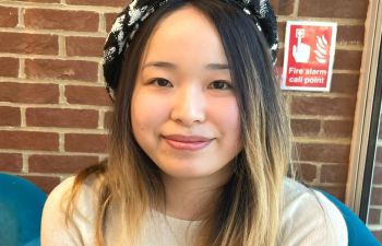 Cooper-Carlson PhD scholar, Yidan Xu wearing a black and white beret and smiling for the camera