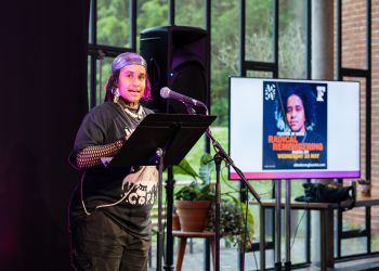 Festival of Ideas: Radical Remembering. Stuart Hall Fellow Subira Joy stands in front of the audience at the Attenborough for the Creative Arts.